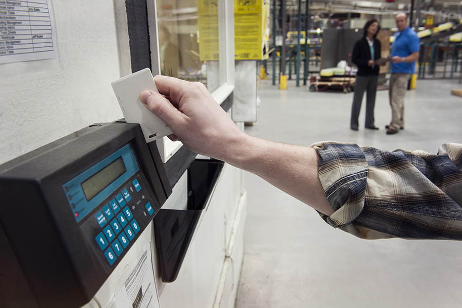 person clocking in at a factory, time clock card